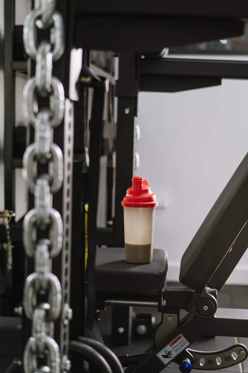 a bottle with a protein shake standing on a machine at the gym